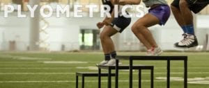 Three young athletes on black table steps on indoor football field with white plyometrics lettering