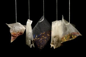 Five bags of different tea hanging with black background