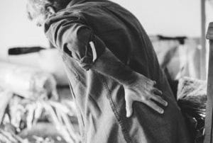 Man holding lower back in pain while bending over