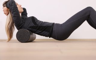 Woman doing balance foam roller exercises.
